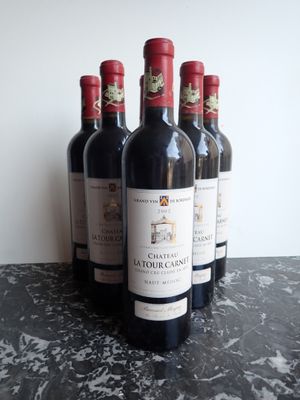 six bouteilles de vin rouge sont alignées sur une table