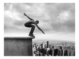 photographie en noir et blanc d'un skateur en train de réaliser une figure sur un rebord devant un paysage urbain