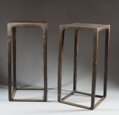 a pair of wooden stools with metal legs on a grey background