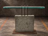 a table with a glass top sitting on top of a concrete block