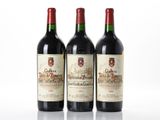 trois bouteilles de vin rouge posées l'une à côté de l'autre sur une surface blanche