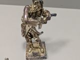 a silver figurine of a man playing a violin