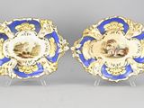 deux assiettes bleues et dorées sur lesquelles figurent les portraits d'un homme et d'une femme