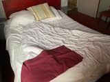 un lit recouvert d'une couverture rouge dans une chambre
