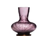 un vase en verre violet posé sur une table