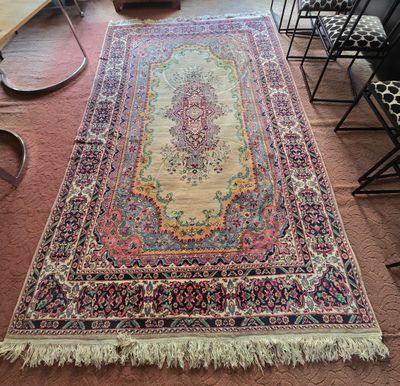 un grand tapis à franges posé sur le sol d'une pièce