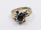 a close up of a ring with a black stone on it