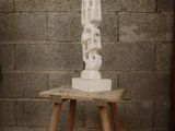 a white sculpture on a small wooden table in a room