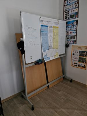 a whiteboard on a stand in the corner of a room
