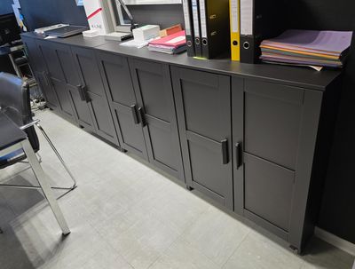un meuble noir sur lequel sont posés tout un tas de dossiers