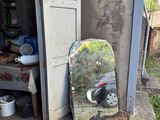a skateboard leaning against a building with a mirror on it
