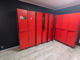 several red lockers are lined up against a black wall in a room
