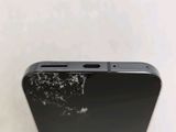 the back of a cell phone with a cracked screen on a white surface