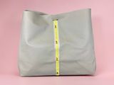 a grey bag with a yellow zipper on the side