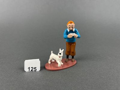 a figurine of a man with a dog next to a calendar