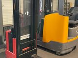 deux chariots élévateurs dans un entrepôt, équipés d'une fourche jaune