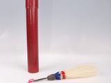 a red tube with a brush next to it on a white surface