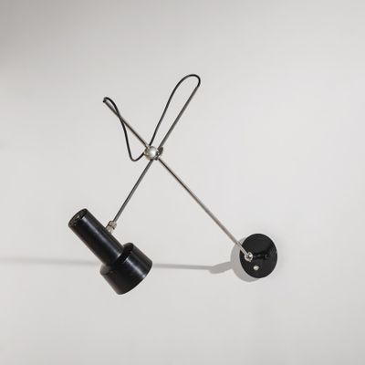 deux lampes noires posées sur une surface blanche, avec un fond blanc