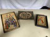 trois photos encadrées représentant des personnes, posées sur une table avec un fond blanc