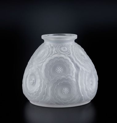 un vase blanc orné de fleurs, posé sur un fond noir