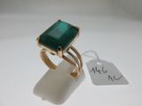 an image of a gold ring with a green stone on it