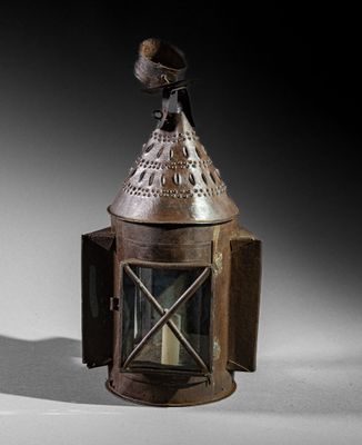 a small metal lantern with a bird on top of it