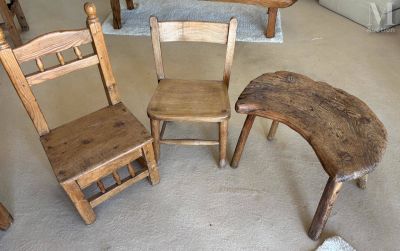 trois chaises en bois et une table dans un salon
