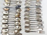 beaucoup de cuillères et de fourchettes posées sur une table