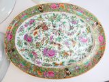 a plate with flowers and birds on it sitting on a table