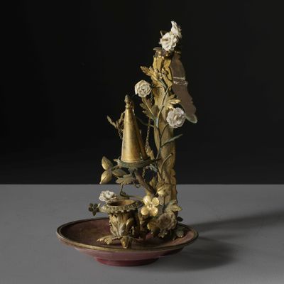 a vase with flowers and a bird on it on a plate