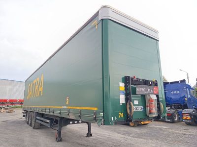 un gros camion vert garé sur un parking