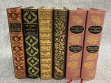 four books are lined up in a row on a gray surface