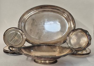 a lot of silver plates and bowls sitting on a table