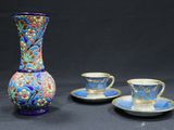 trois tasses et un vase posés sur une table