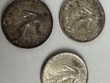 four different types of coins are shown on a white surface