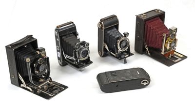plusieurs vieux appareils photo sont alignés sur une surface blanche