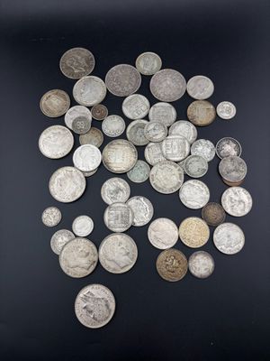 une image représentant un tas de pièces d'argent posées sur une surface noire