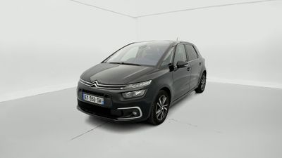 Une Citroën noire est garée dans une pièce blanche