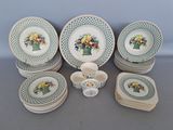 many plates and cups with flowers on them on a table