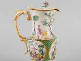 un vase blanc et vert orné d'un oiseau et de fleurs
