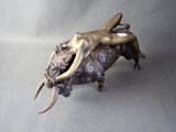bronze statue of a woman laying on top of a bull on a gray background