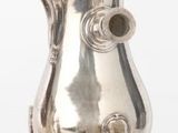 une théière en argent et deux théières en argent posées sur une table