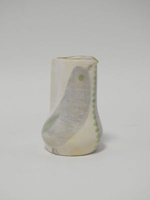 un vase blanc orné d'un motif vert