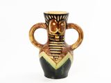 a brown and black vase with a face on it