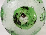 a green glass vase with a hole in it