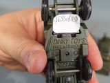 someone is holding a toy army vehicle with a sign on the back of it