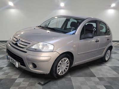 la photo d'une petite voiture argentée garée dans un garage