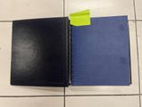a black notebook with a yellow sticker on top of it
