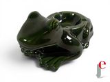 a green frog figurine sitting on a white surface