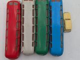 four different colors of toy buses on a white surface